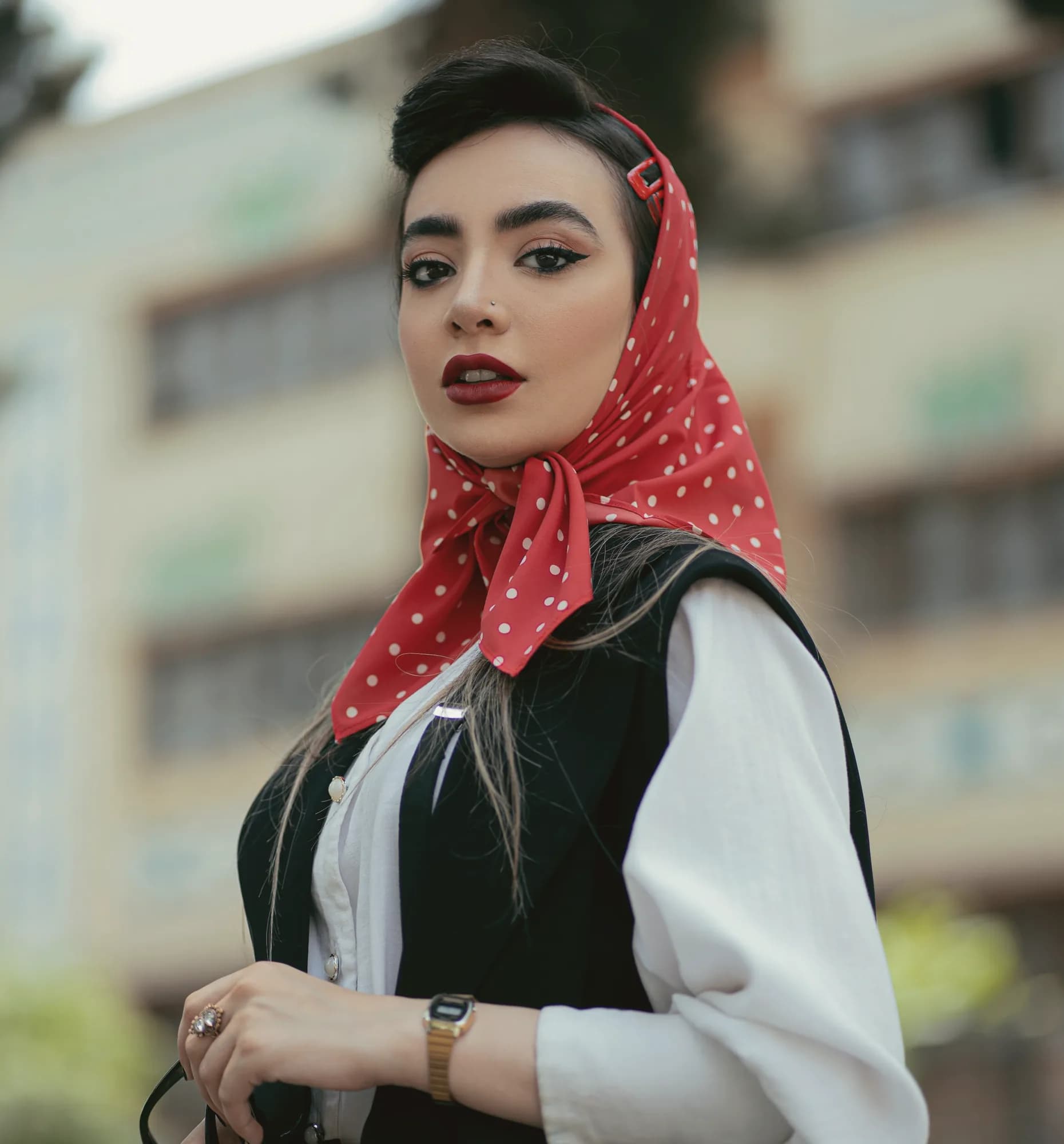 زنی با روسری خال‌خالی قرمز و جلیقهٔ مشکی