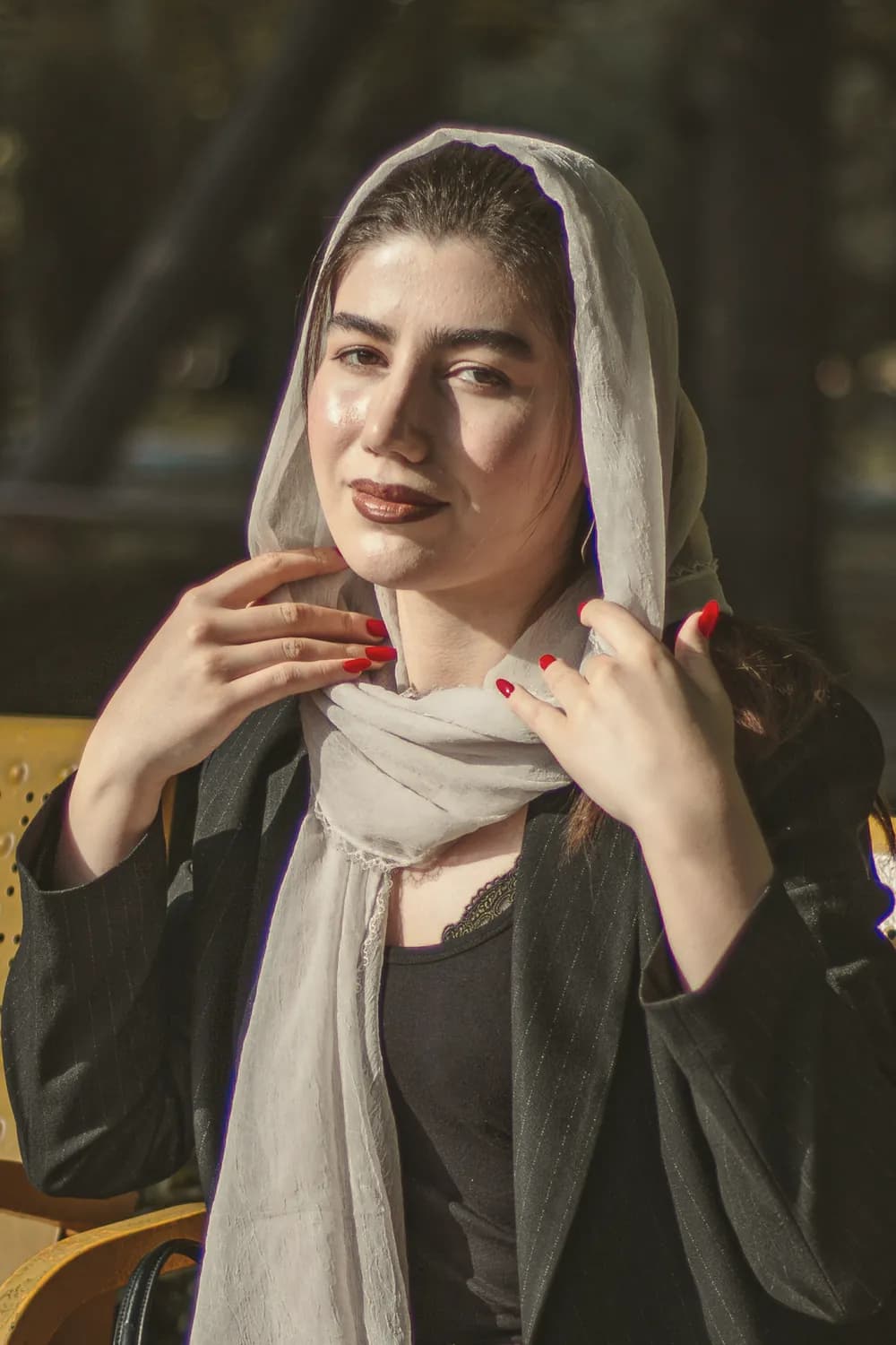 زنی با شال روشن و کت مشکی